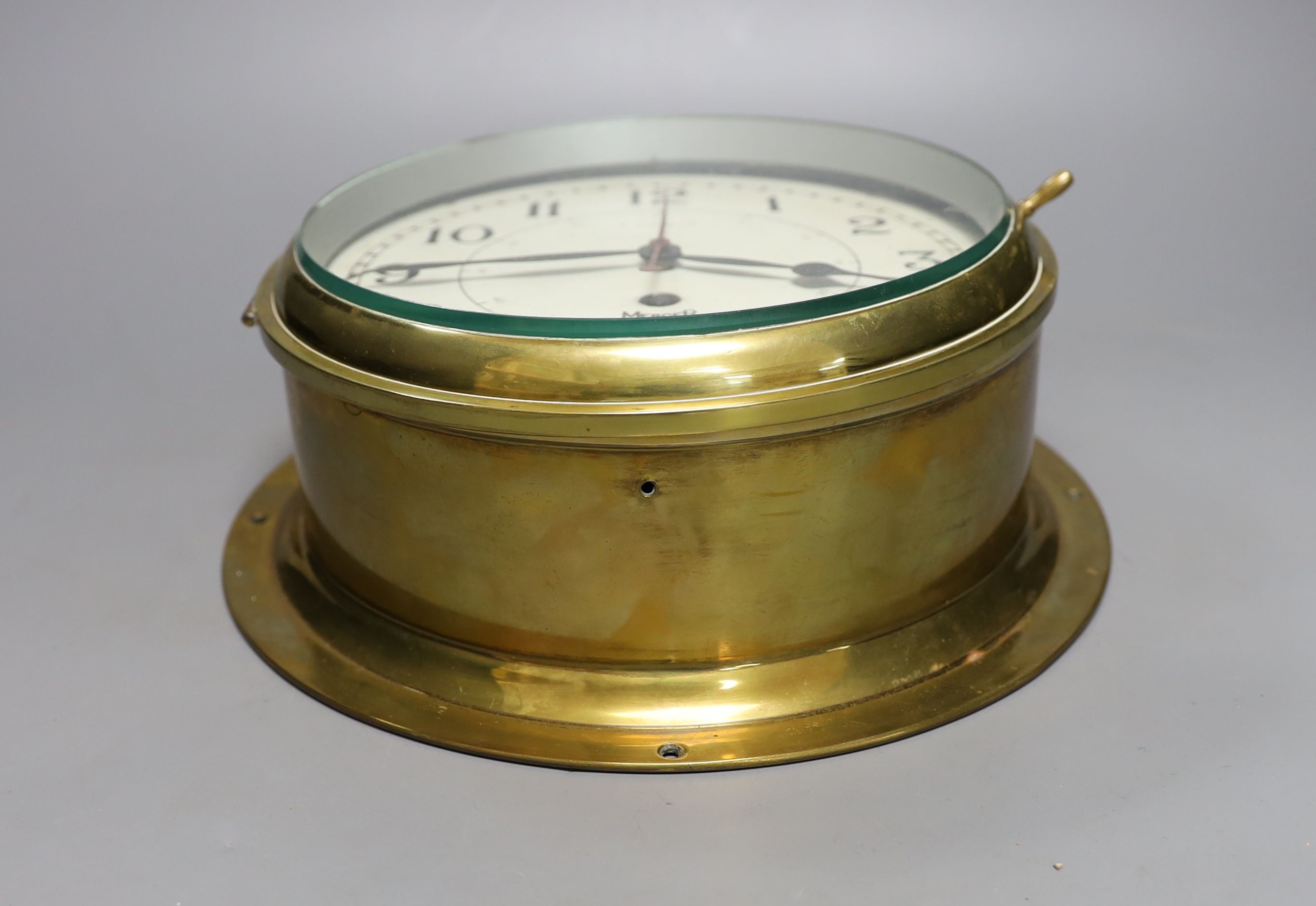 A Mercer brass bulkhead timepiece, 25 cms wide.